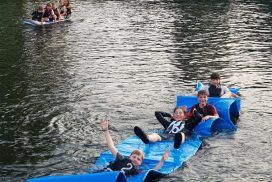 Kinder auf Matte im Wasser