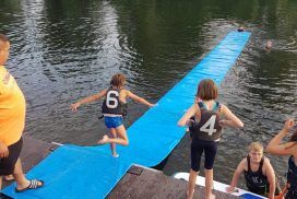 Kind läuft über Matte im Wasser